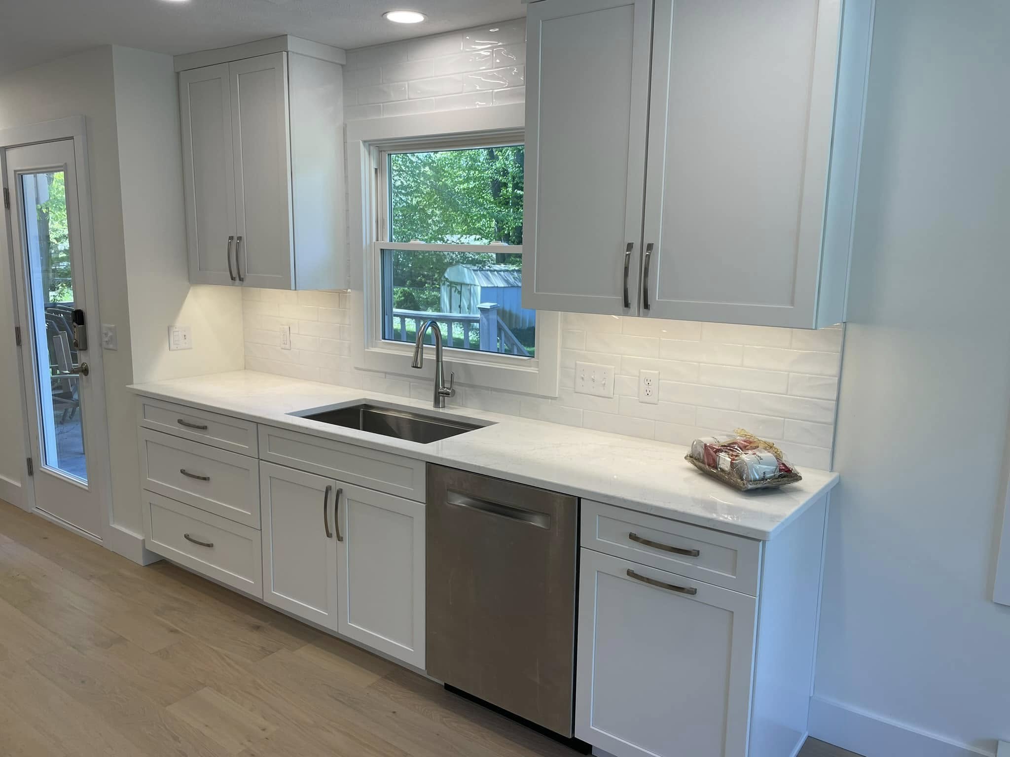 Updated kitchen with sleek white cabinetry, subway tile backsplash, and bright modern finishes