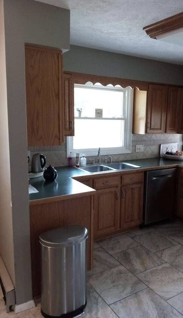 Outdated kitchen with dark wooden cabinets, gray walls, and limited counter space.