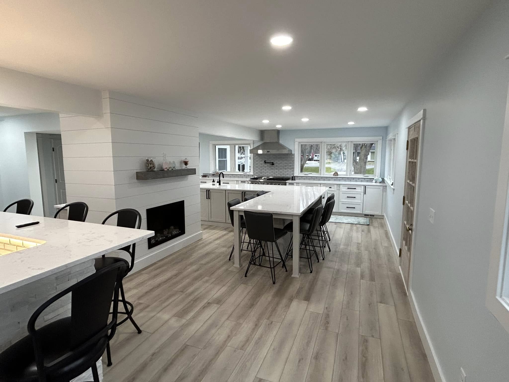 Kitchen and dining renovation with new flooring, white cabinetry, and recessed lighting by Vanderlee Construction, LLC.