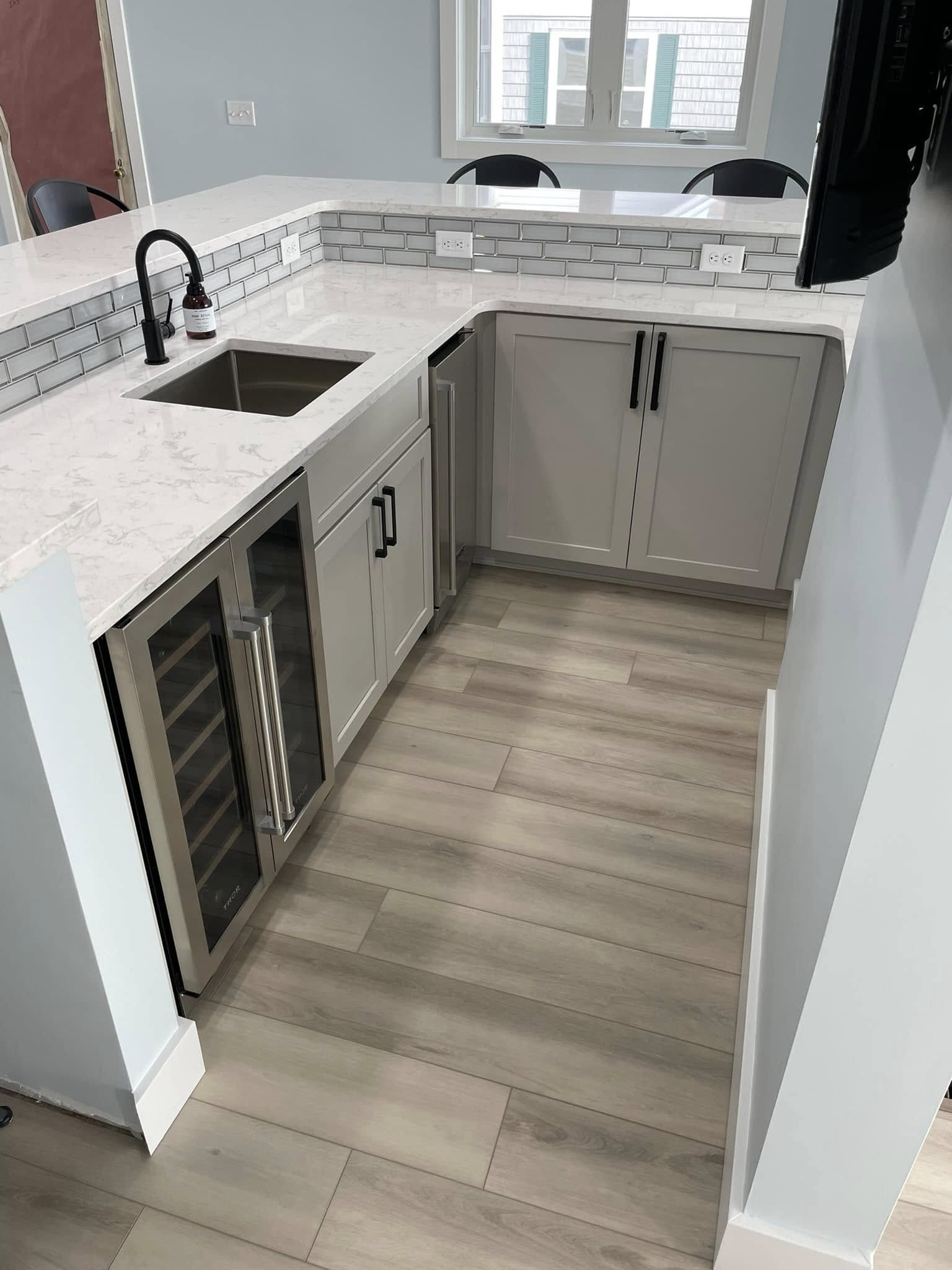 Stylish bathroom remodel with modern gray cabinetry, tile backsplash, and bright lighting by Vanderlee Construction, LLC
