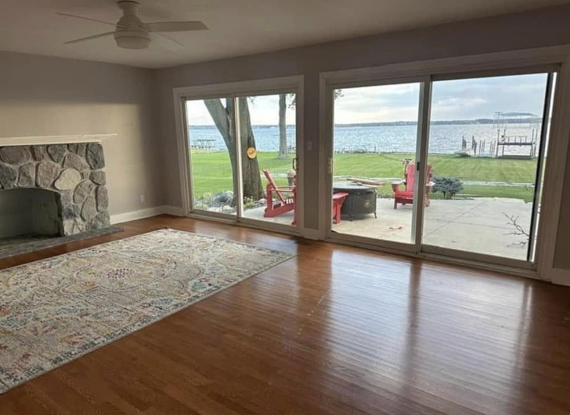 Outdated living room with carpet and old fireplace before remodel by Vanderlee Construction, LLC