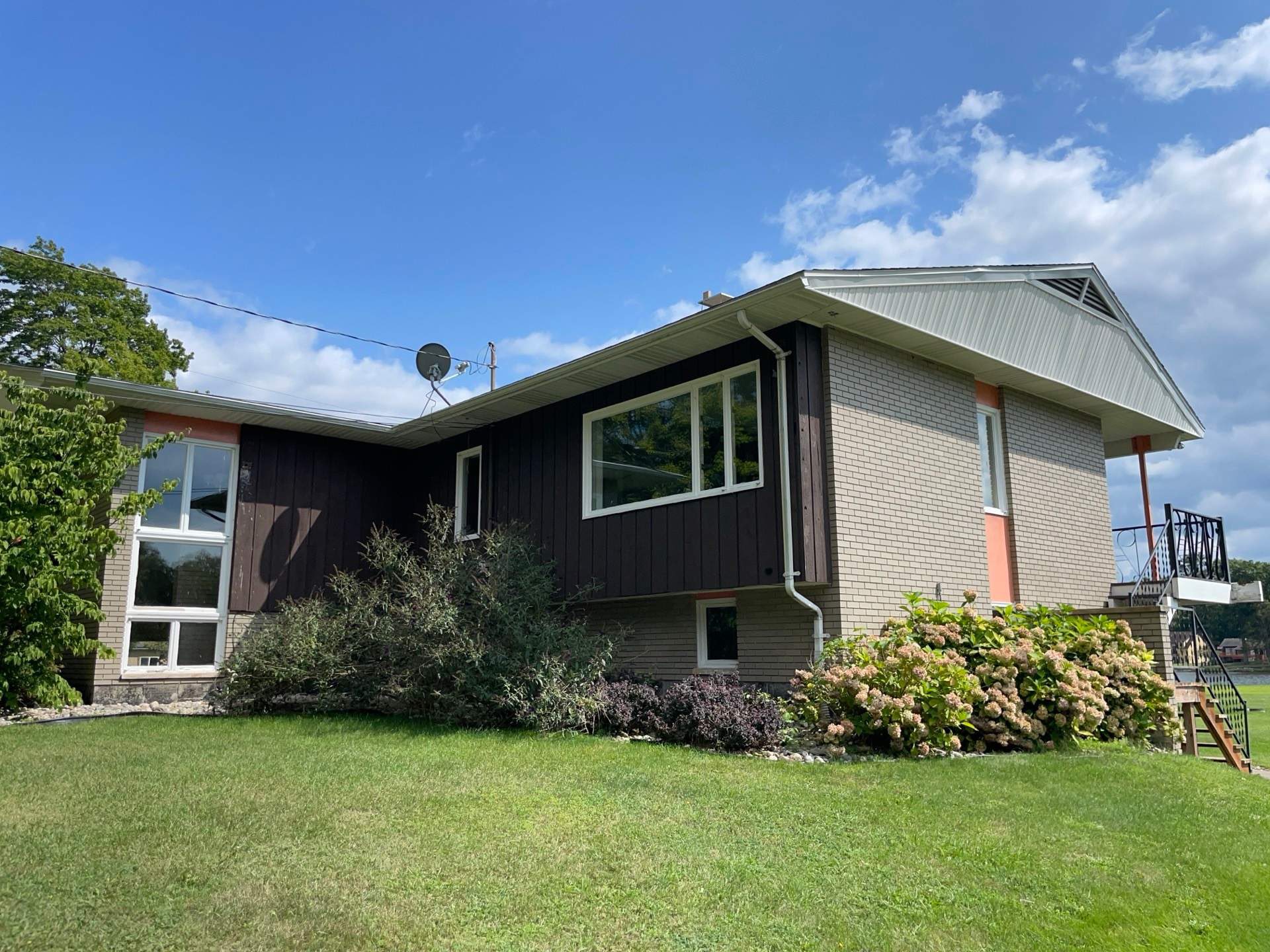 Split-level house with dated brown siding and older windows.