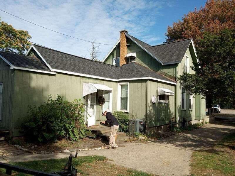 Outdated home with light green siding and worn exterior