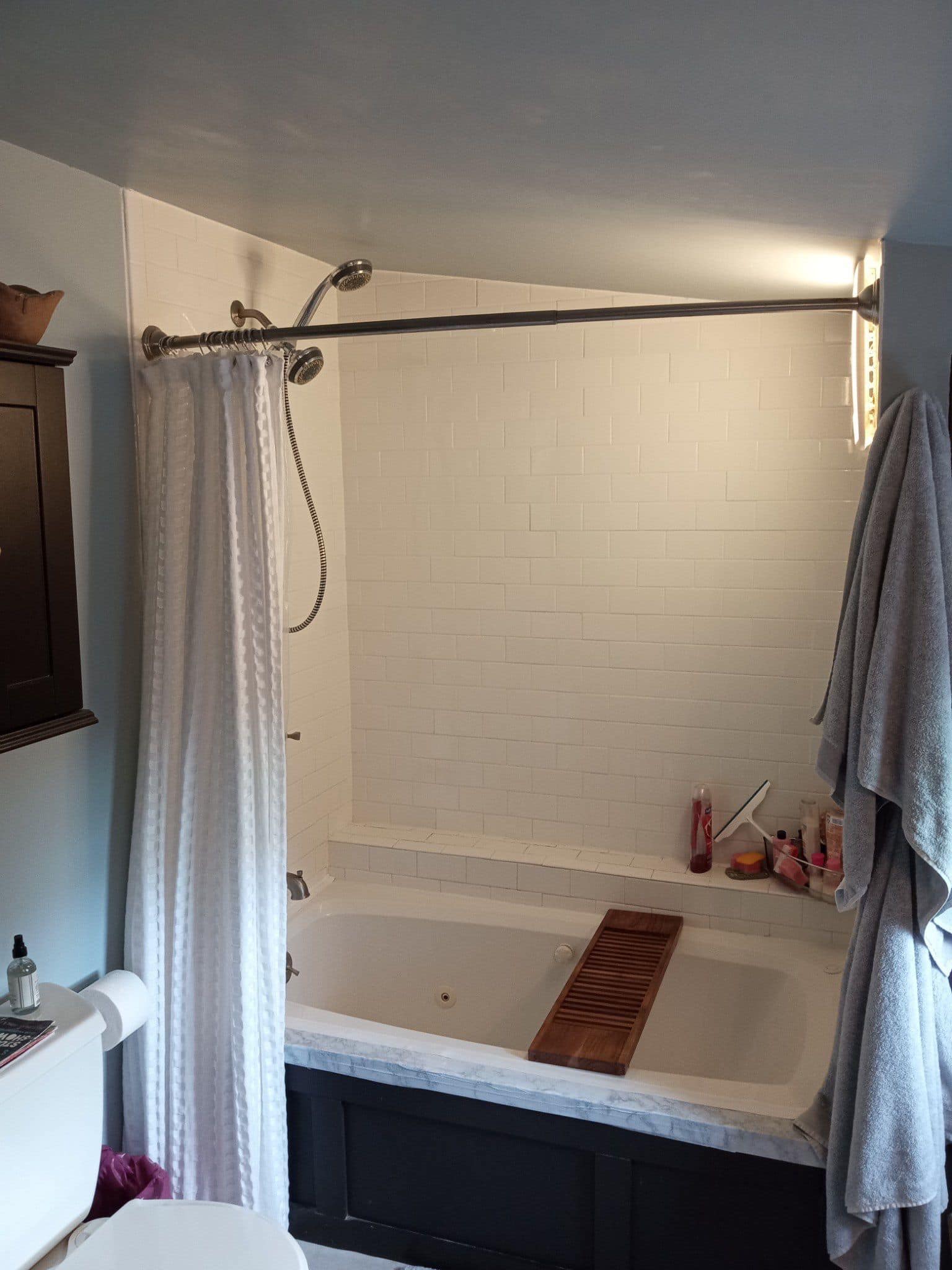 Old bathroom with bathtub, dark cabinetry, and outdated fixtures.