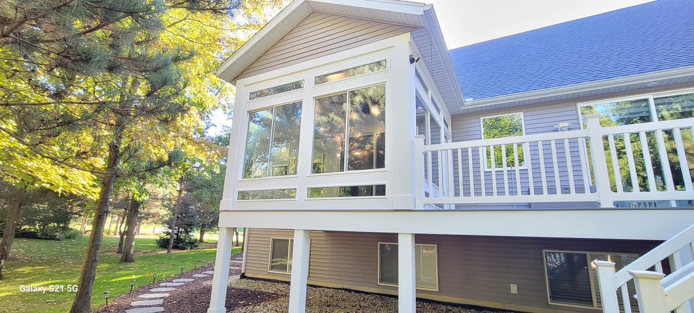 Beautiful new screened porch with white railing and upper-level deck built by Vanderlee Construction, LLC
