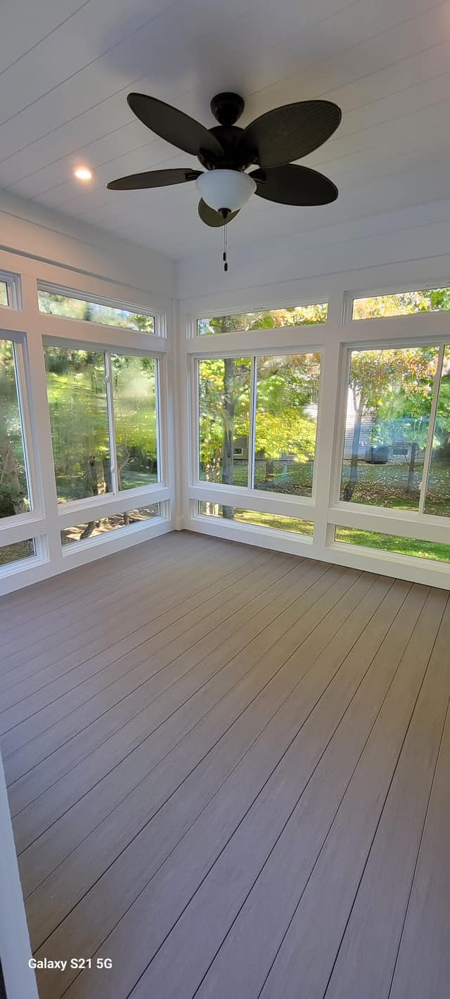 Modern sunroom remodel featuring ceiling fan, large windows, and bright interior by Vanderlee Construction, LLC.